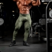 Bodybuilder wearing compression pants in army green color. 