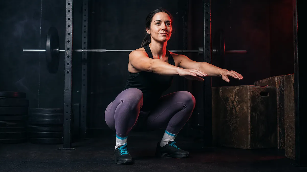 Sara in a deep bodyweight squat in high-waist seamless leggings